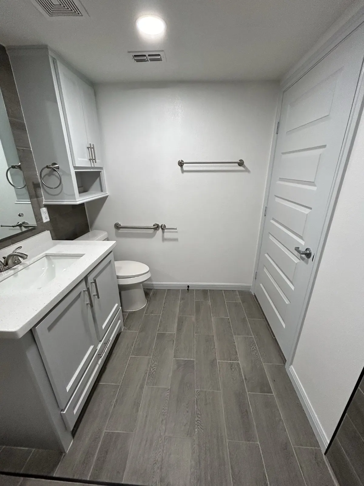 Remodeled bathroom — modern gray tile with new vanity and fixtures