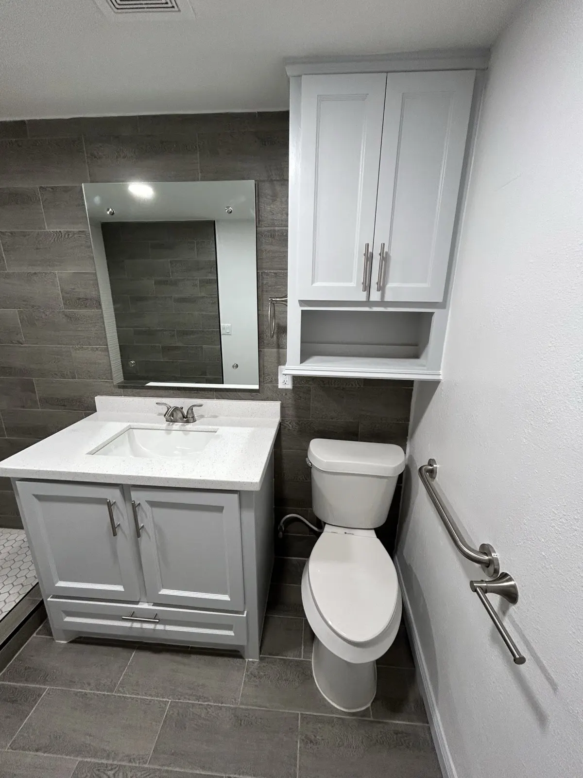 Remodeled bathroom — new white vanity with medicine cabinet and gray tile