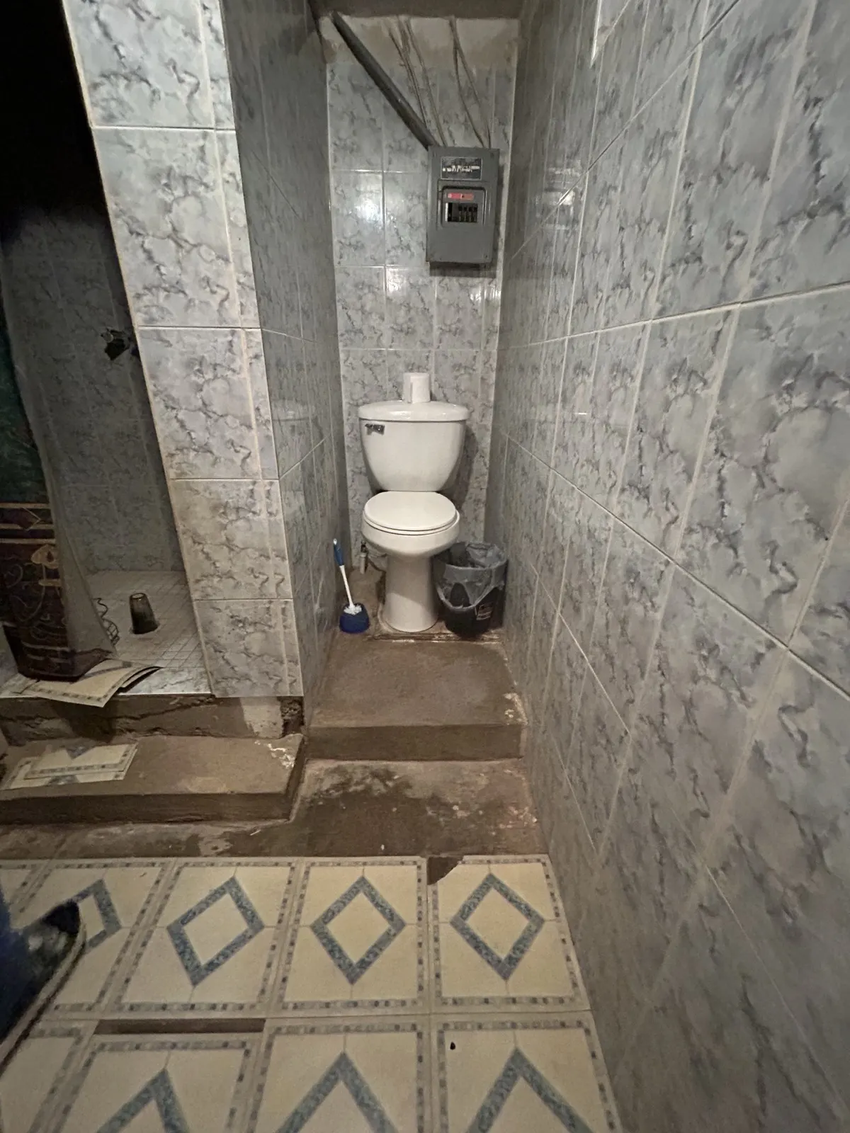Bathroom before remodel — outdated tile and fixtures