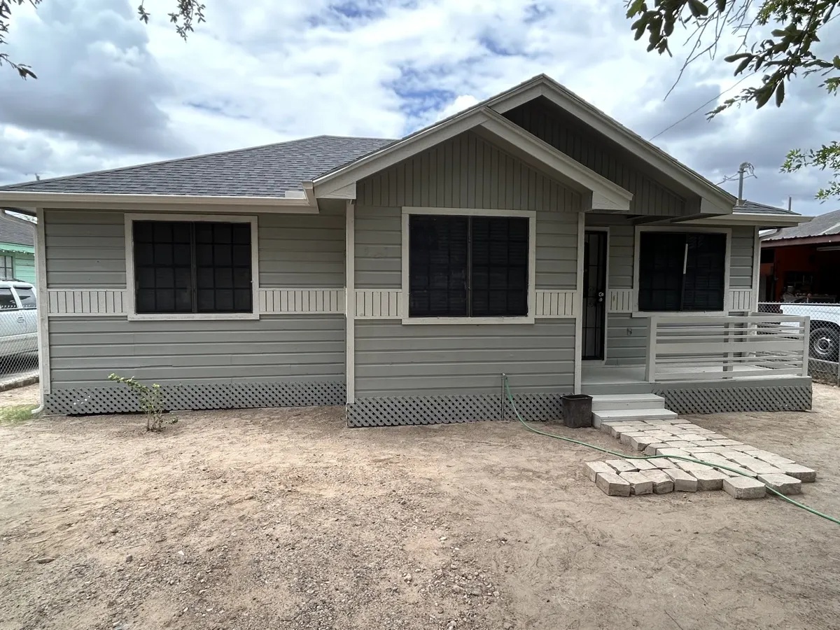 Home exterior after repair — fresh gray paint with new siding and trim
