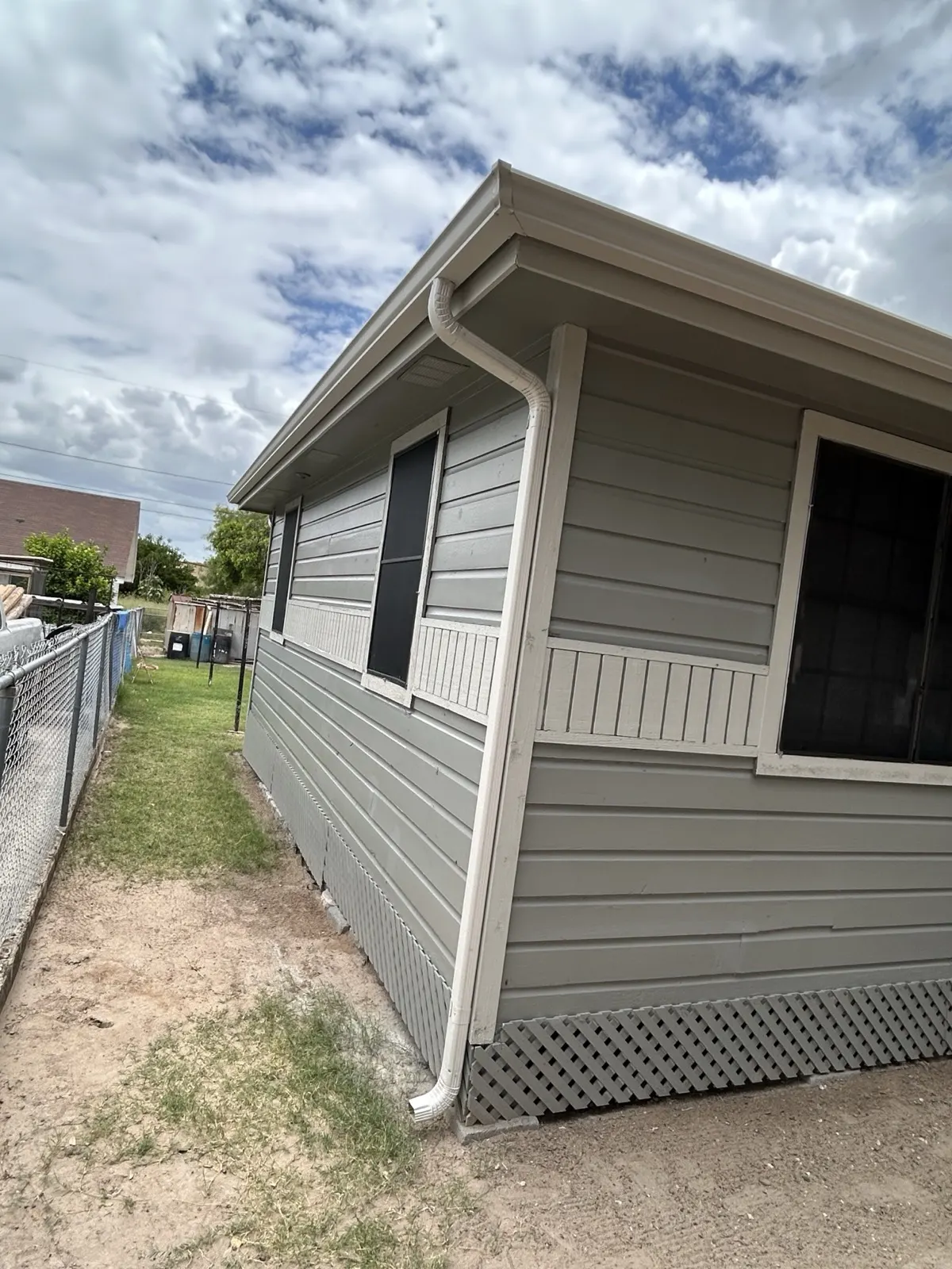 Repaired exterior — fresh paint and new siding from side angle