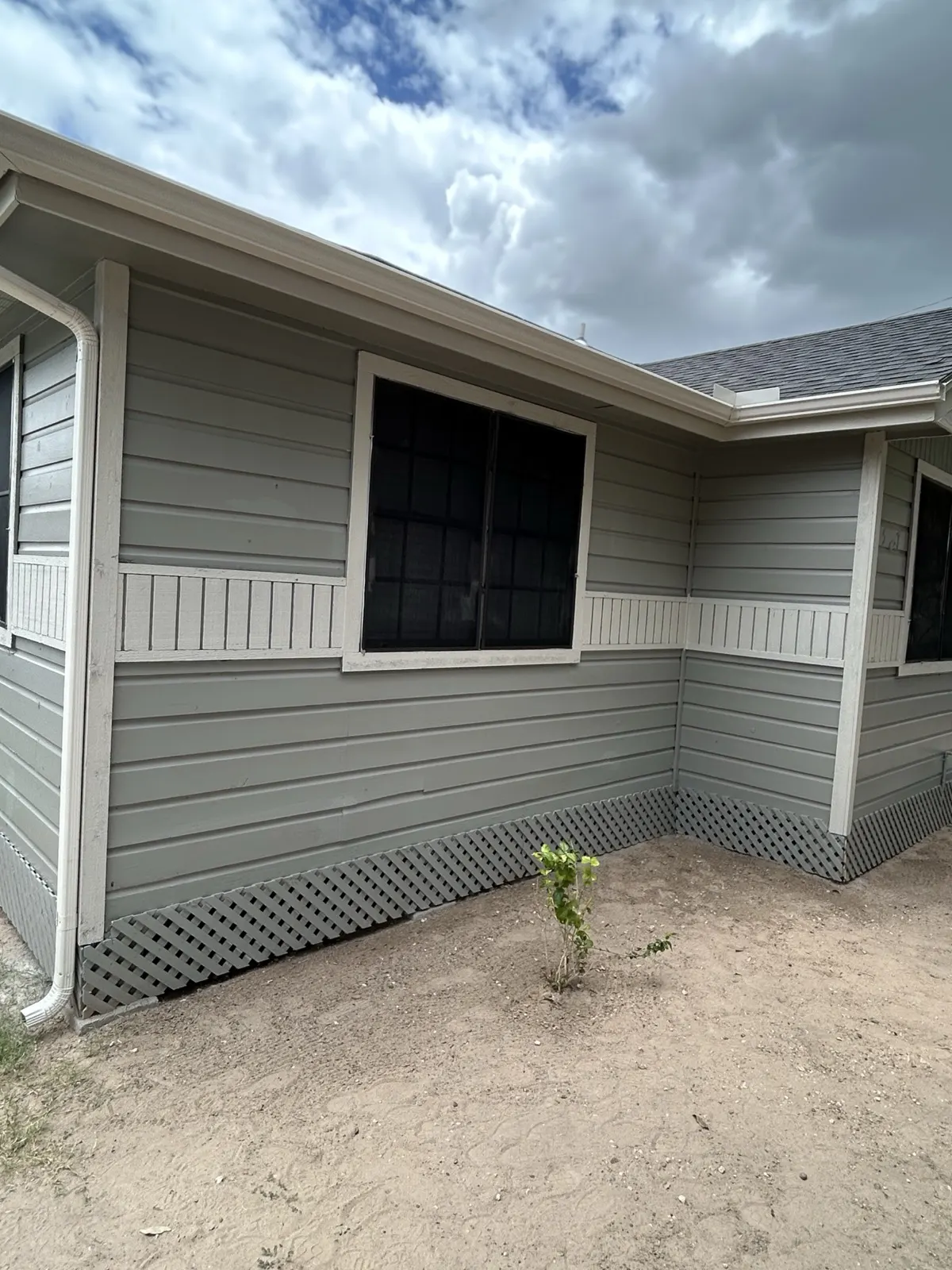 Repaired exterior — completed siding and paint from rear angle
