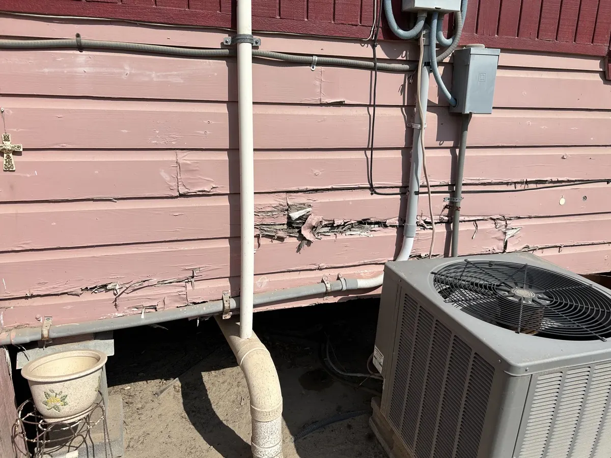 Exterior damage — peeling and cracking paint on siding