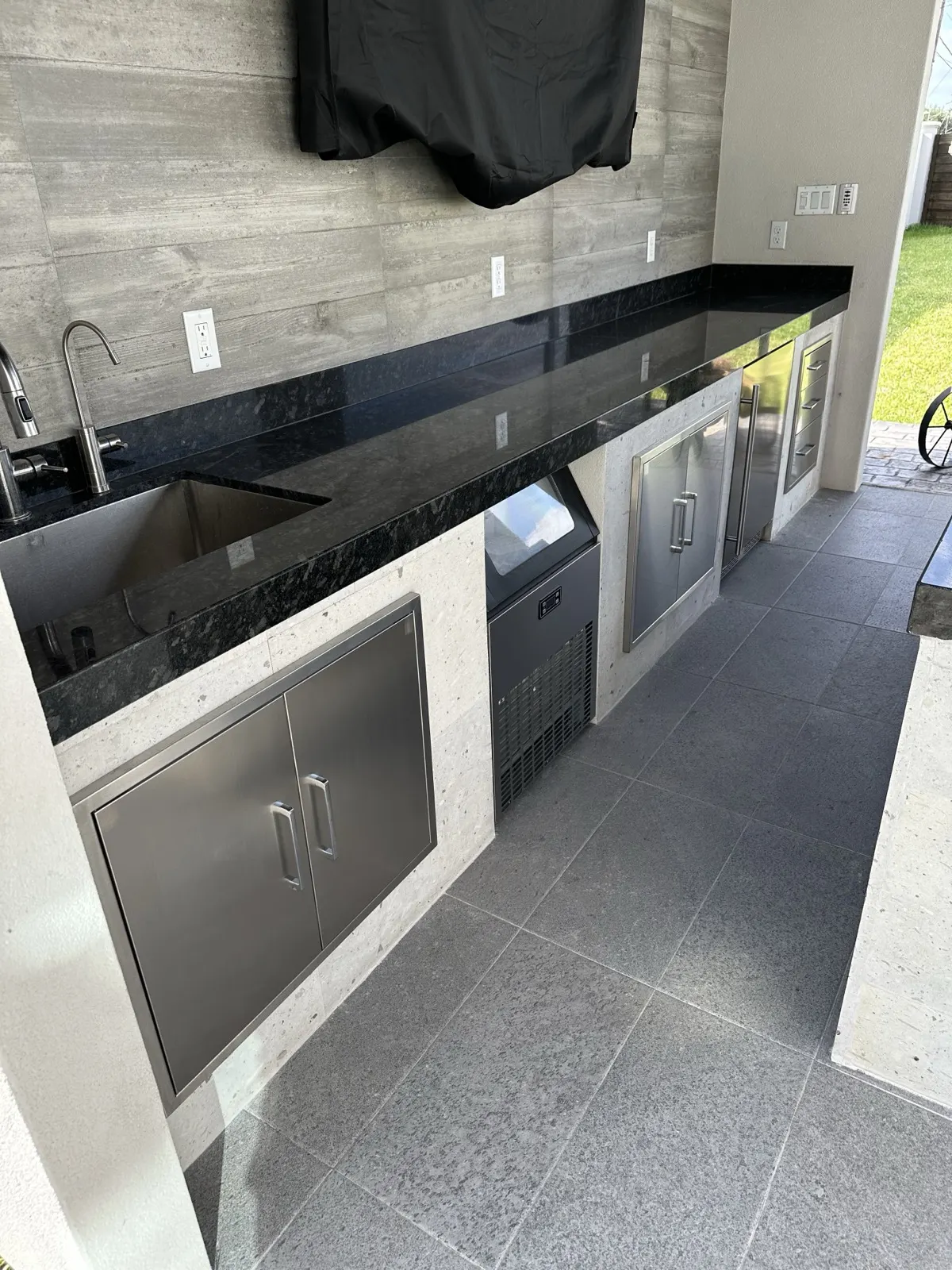 Finished outdoor kitchen — built-in grill, cooktop, and stainless steel drawers