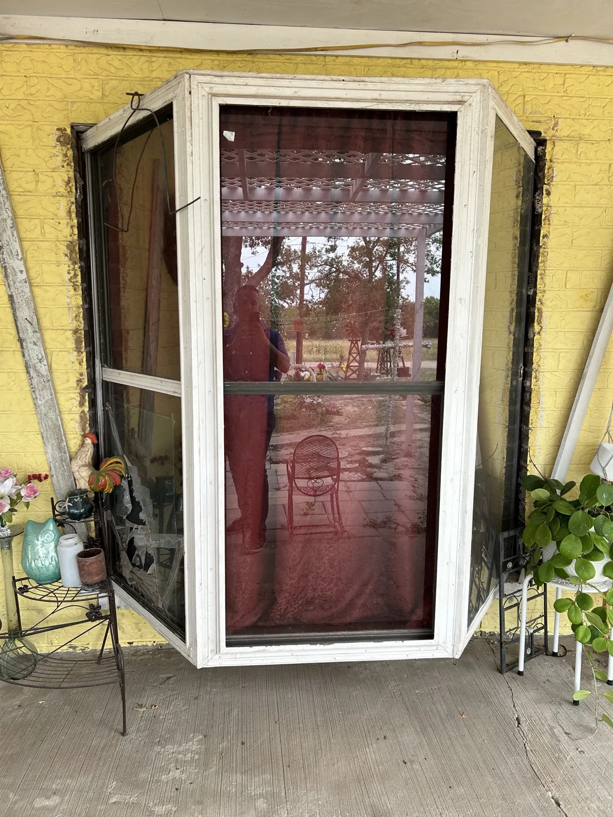 Old window before replacement — worn frame on yellow wall